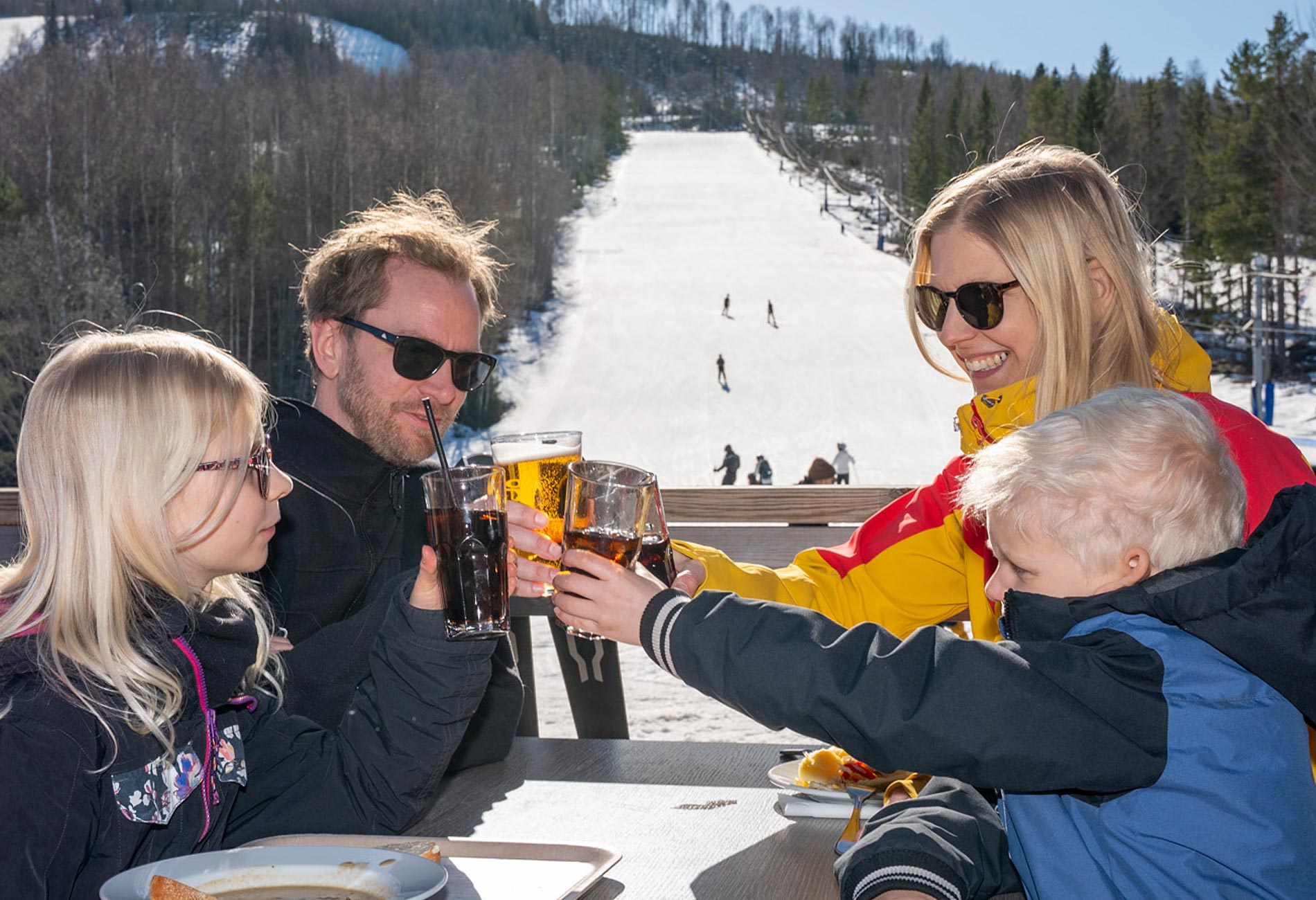 Familj njuter av en prisvärd skidsemester på verandan i Hassela Ski Resort nära Stockholm